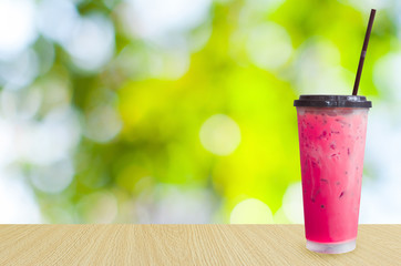 Ice tea,iced pink milk tea on green nature background ,Summer drinks with ice