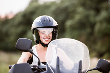 Naklejka premium Pretty blond woman enjoying a motorbike ride in countryside.