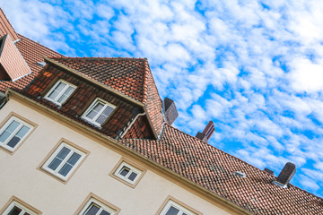 Hausdach mit wolkigem Himmel