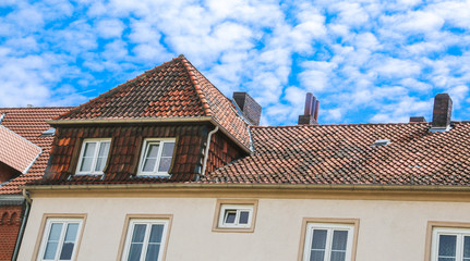 Hausdach mit wolkigem Himmel