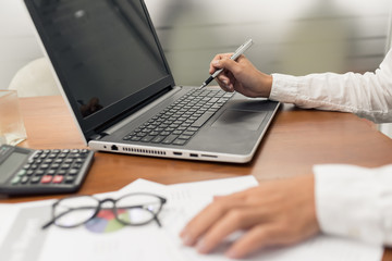 Young businesswoman working with document and laptop computer in office.