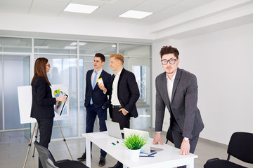 Businessman with glasses on the background of business people in a modern office.