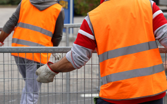 workers with orange high-visibility vest while moving the iron f