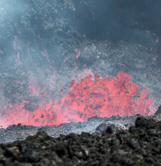 Boiling lava and volcanic bombs in a breakthrough on the slopes of the crater of the volcano cone...