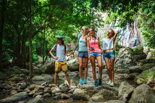european tourists hiking in thailand standing on rocks by stream