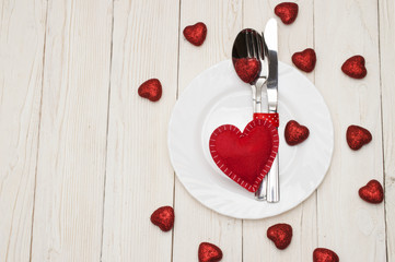 Table set for celebration Valentine's Day. Wooden place setting with red heart .