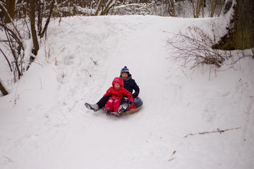 children riding a snow hill