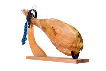 Leg of dried pork meat - ham on a wooden stand. Isolated on white background