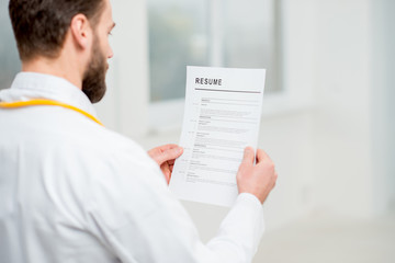 Doctor reading resume for job hiring in the hospital
