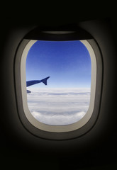 Fototapeta na wymiar Airplane porthole view of clouds.