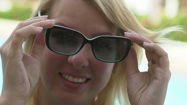 Sexy blonde woman wearing sunglasses and smile