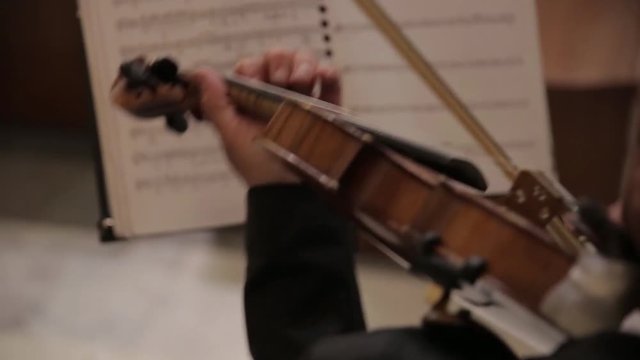 Female violinist plays violin at a classical music concert against Vivaldi note sheet