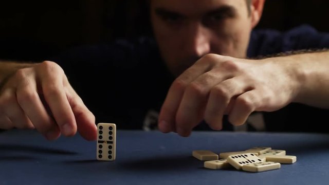 Man set up the domino with hand. Domino effect