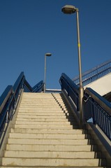 Concrete stairs with blue railing and two lamps