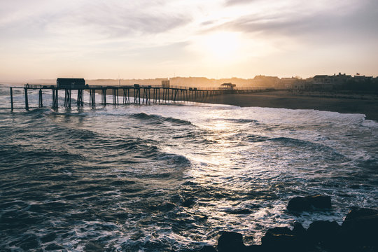 Pier in sea at sunset
