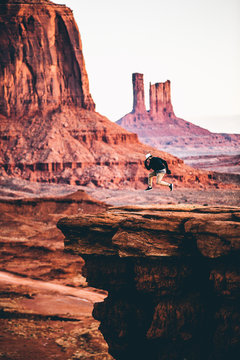 Man in mid air jumping on sandstone rocks