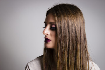 Naklejka premium Piękny boczny portret kobiety. Kobieta patrzeje w odległości z makeup na jej twarzy. Portret młodej strony brunetka.