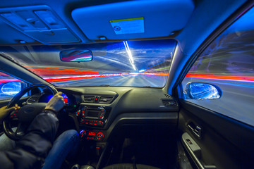 The car moves at great speed.Blured road with lights with car on high speed. Concept rapid rhythm of a modern city.