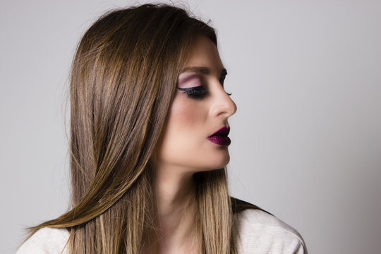 Beautiful woman side portrait. Woman with makeup on her face looking in the distance. Young brunette side portrait. Beautiful hair.