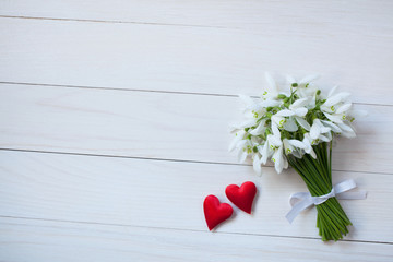 Bouquet of snowdrops on a wooden light background