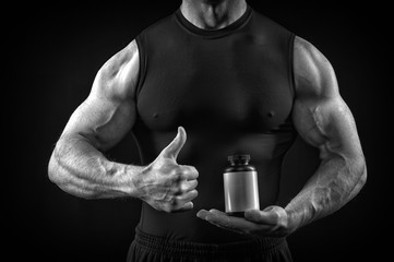 handsome sexy athlete man with muscular body holds steroid jar