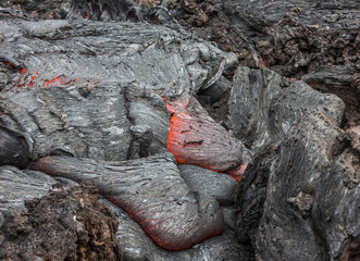 Molten lava flows on the surface of the cracks in the previously cooled lava - volcano Tolbachik,...