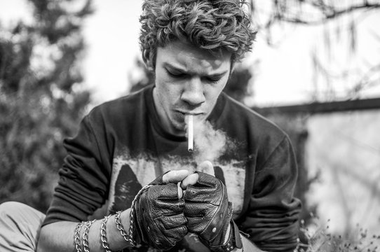 Young cool rocker smoking cigarette black and white	