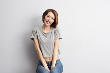 Beautiful, slim girl sitting on a chair and looking confidently