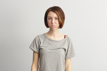 Obraz premium Girl puffed out her cheeks. She is offended and dissatisfied.