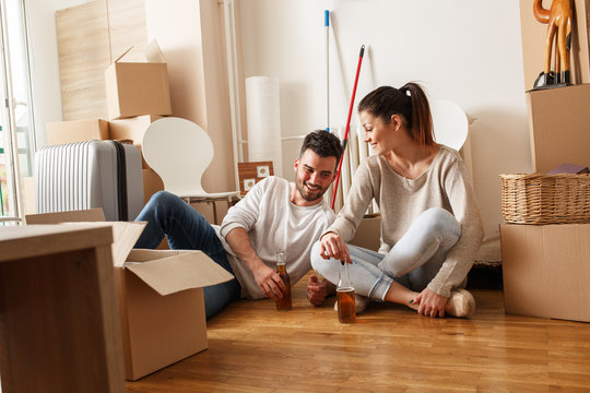 Young couple Moving in new home.Sitting on floor and relaxing after cleaning and unpacking.