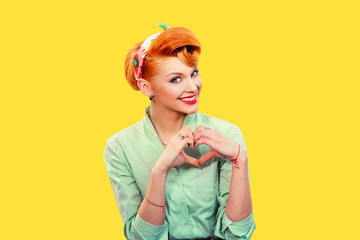 Closeup portrait smiling cheerful happy young woman making heart sign with hands isolated on grey...