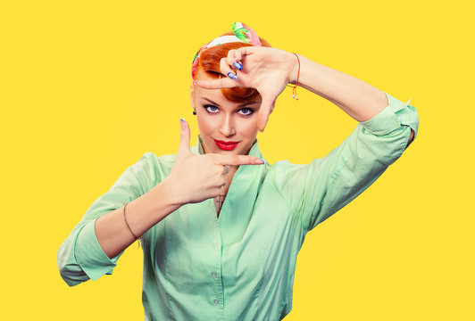 Young pin up retro hair style girl woman making framing key gesture on yellow