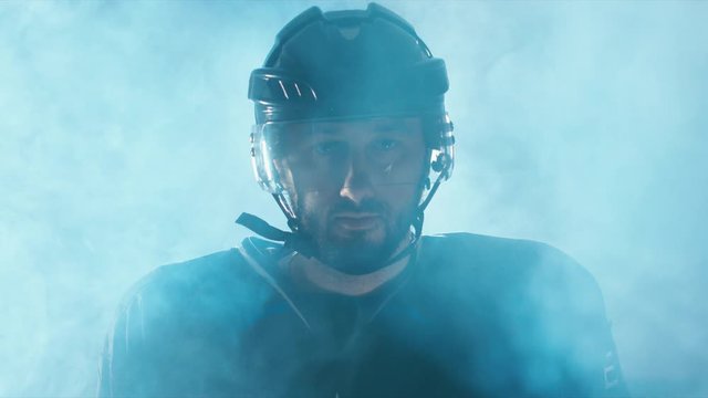 CINEMAGRAPH - seamless loop. CU Portrait of Caucasian male ice hockey player in black uniform, looking into the camera