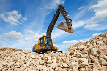 Excavator unload gravel. The stones for the road. Unloading ston