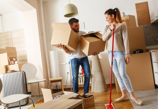 Young couple cleaning and selecting things at they new home.Moving house.
