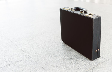 An old black leather briefcase on the floor