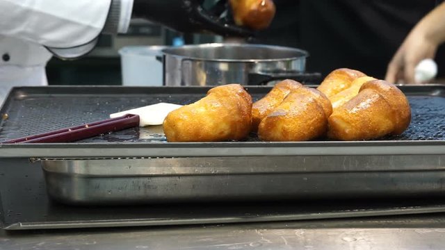pastry chef prepares babb&agrave; draining them from the wet alcohol