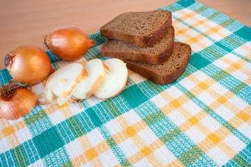 Black sliced bread and onions on a checkered towel