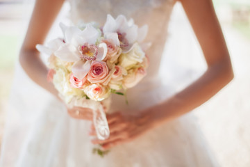 bride hold wedding bouquet of rose peonies and roses
