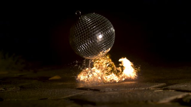 Disco ball falling and catching fire, slow motion