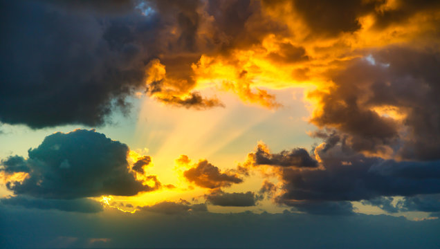 Dramatic sunset sky with yellow, blue and orange thunderstorm