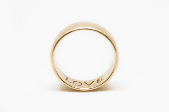 A gold ring with the word love on the inside