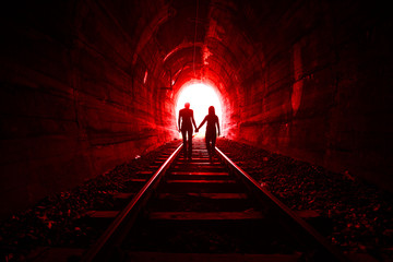 Couple in love walking together through a railway tunnel