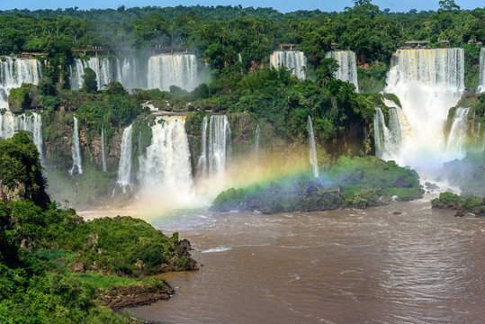 Aerial view of waterfalls cascade of Iguazu Falls with extensive tropical forest and beautiful rainbow in Iguacu National Park, UNESCO World Heritage Site, Foz de Iguacu, Parana State, Brazil