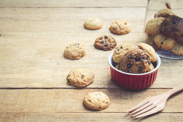Cookie in red cup on wood table with copy space. vintage tone. Selective focus.