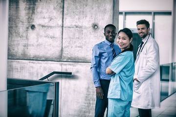 Nurse and doctor with businessman standing in hospital
