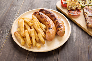 grilled sausage with french fries on wooden background