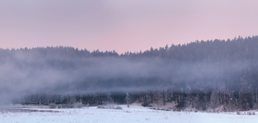 Fototapeta premium Rows of white fog over snow