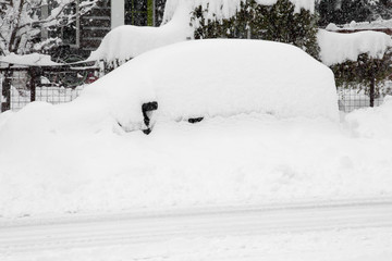 Parked car buried in a snow drift