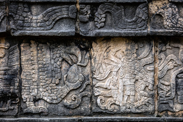 Ancient Mayan mural depicting an eagle grasping a human heart and a warrior holding a human head on the Platform of the Skulls, a.k.a. Tzompantli in Chichen Itza, Yucatan, Mexico